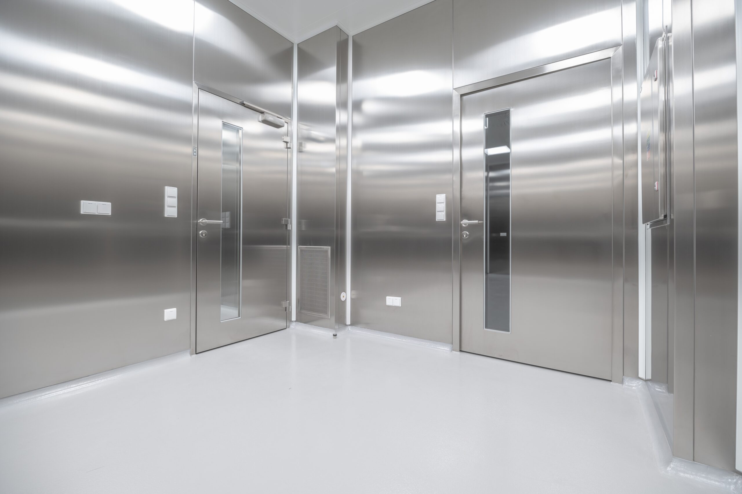 An empty room with a bunch of stainless steel doors